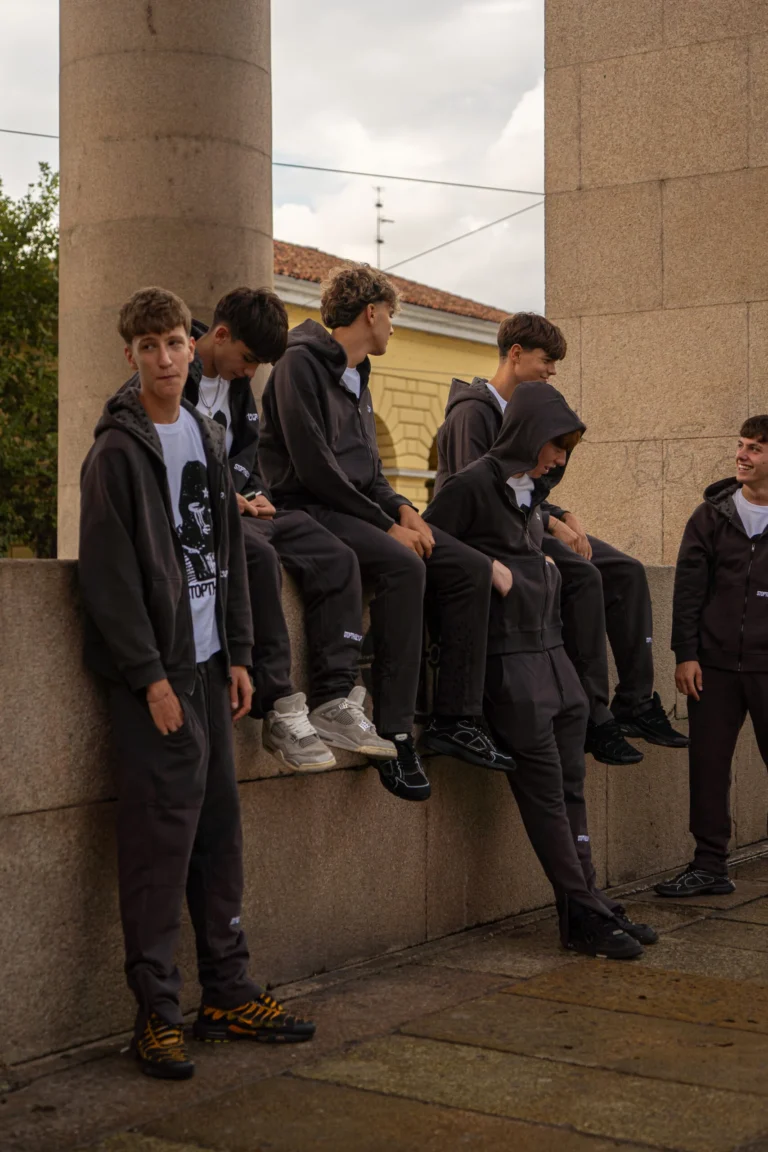 Group in LOOP tracksuits sitting on a wall
